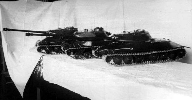 Деревянные модели вариантов модернизации танка ИС, представленные конструкторами опытного завода № 100 весной 1944 года: в середине (для сравнения) ИС-2, справа и слева — машины с опорными катками большого диаметра со сварным и литым корпусами (АСКМ).